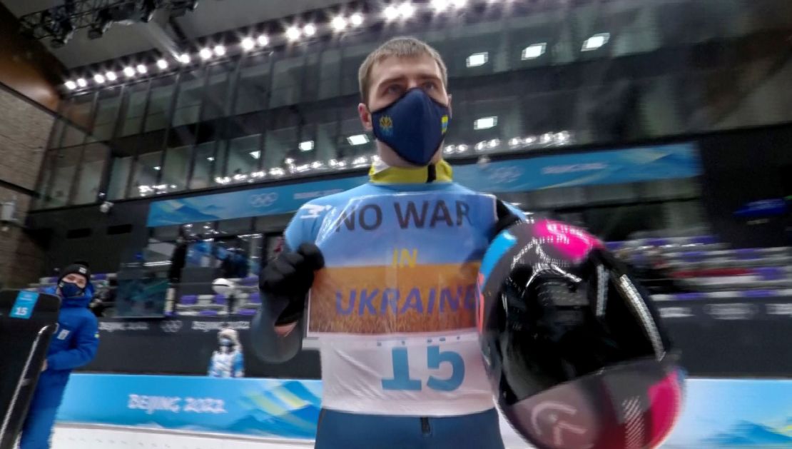Heraskevych holds a sign with a message reading "No war in Ukraine."