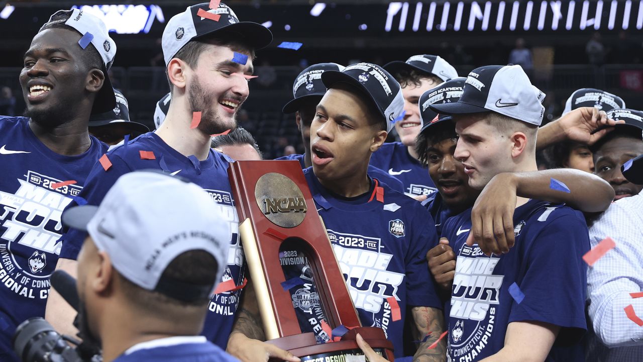 Jordan Hawkins celebrates with teammates and the trophy after UConn defeated the Gonzaga Bulldogs in the Elite Eight.