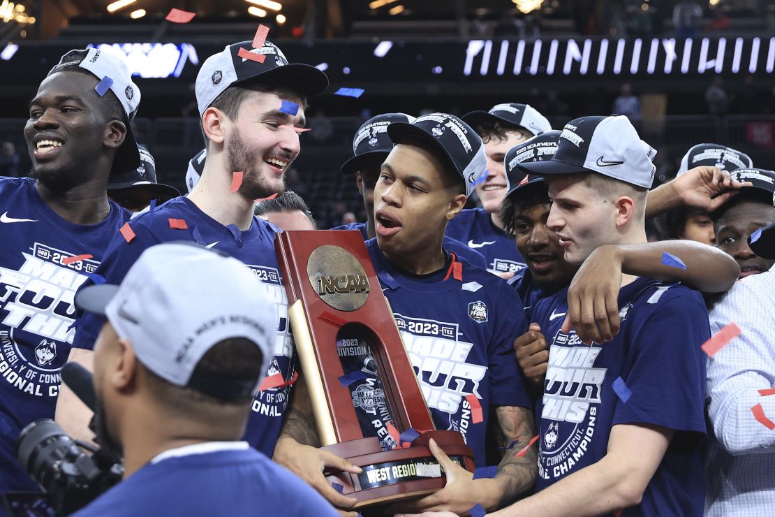 Jordan Hawkins celebrates with teammates and the trophy after UConn defeated the Gonzaga Bulldogs in the Elite Eight.