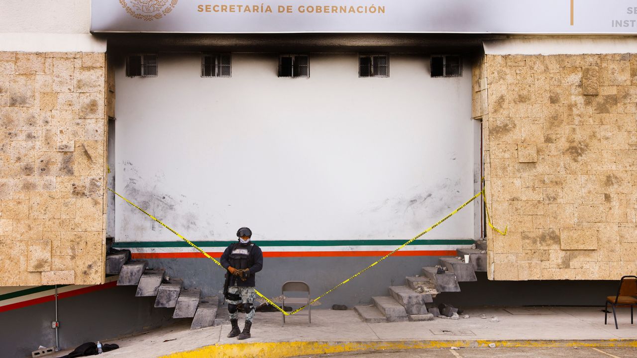 A member of the Mexican National Guard stands INM building, following Monday's deadly blaze.