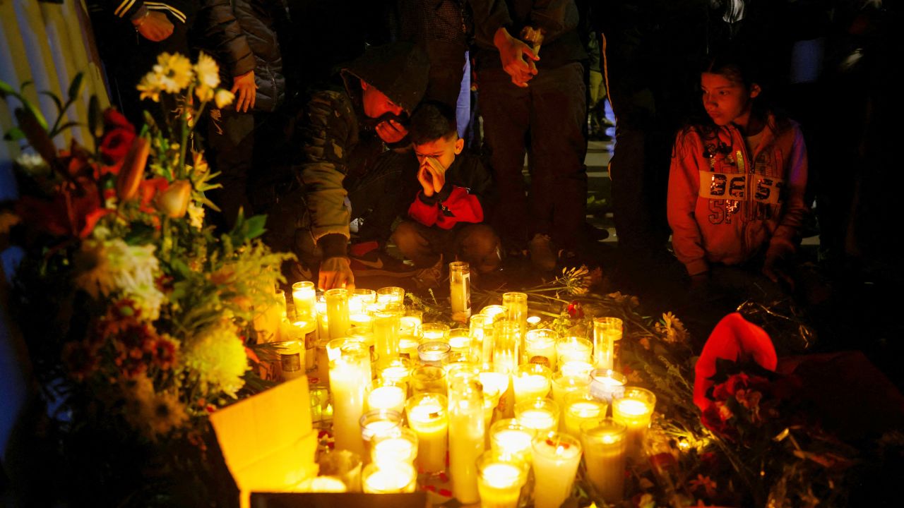Migrantes realizan una vigilia con velas frente a la oficina del Instituto Nacional de Migración (INM) en memoria de las víctimas del incendio.
