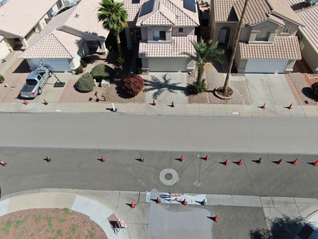 In Phoenix, Arizona, the local government is using "cool pavement" to combat rising temperatures. The water-based asphalt treatment is sprayed on top of existing pavement to reflect, rather than retain heat. Pictured, a residential street with half the pavement treated already.