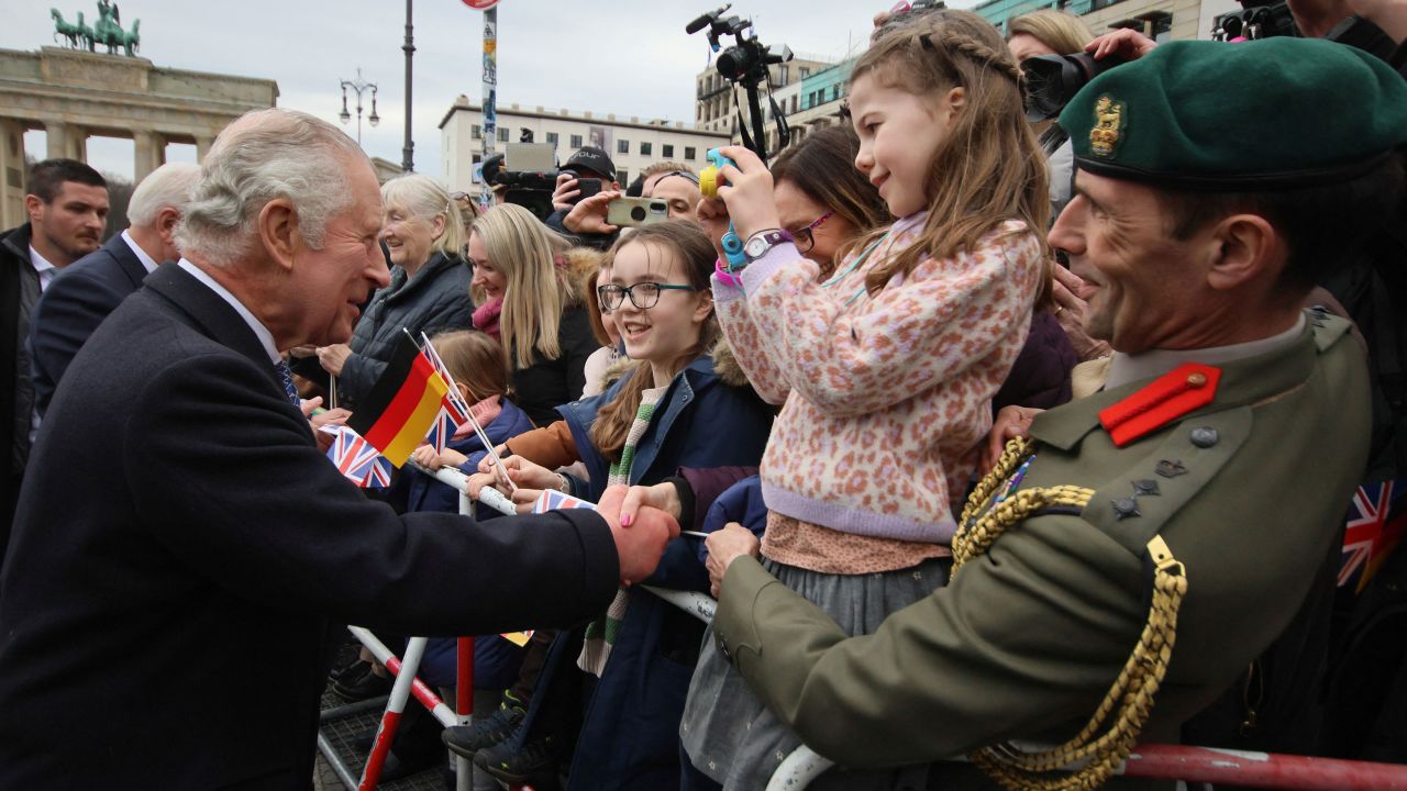 El rey Carlos saluda a la gente en la Puerta de Brandenburgo el primer día de su visita de estado a Alemania. 