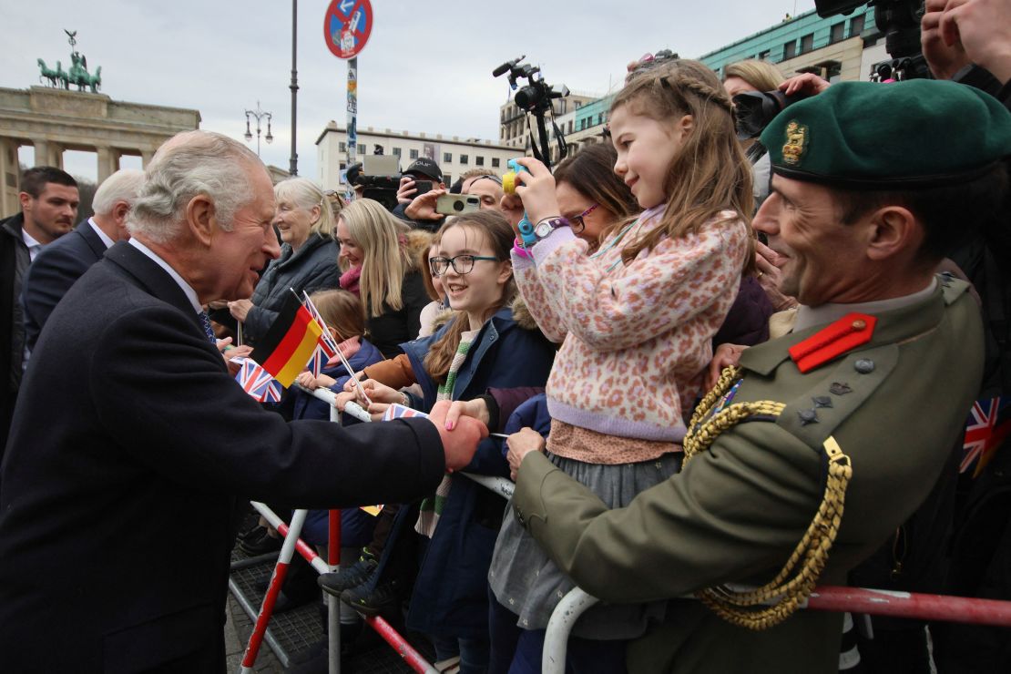 King Charles greets people at Brandenburg Gate on the first day of his state visit to Germany. 