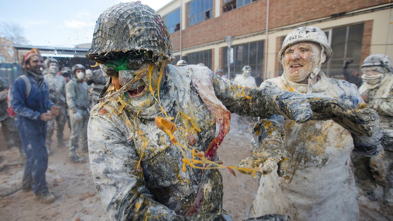Revellers dressed in mock military garb take part in "Els Enfarinats" food-battle in the southeastern Spanish town of Ibi on December 28, 2022, a celebration very similar to April Fools' Day.