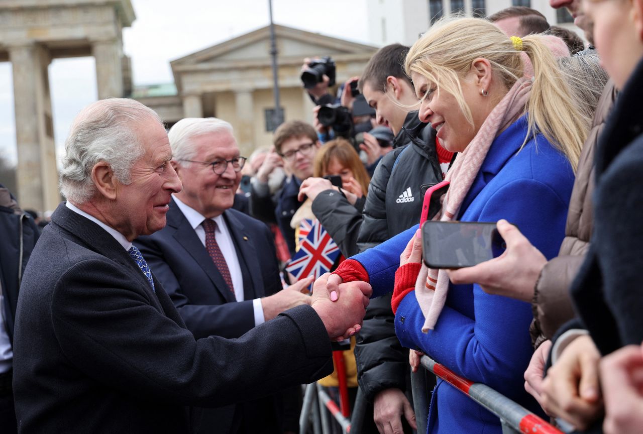 The King shakes hands with well-wishers at Brandenburg Gate.