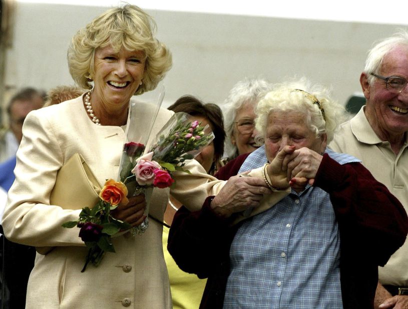 Dorothy Edwards kisses Camilla's hand as she attends the Sandringham Flower Show in England in 2003.