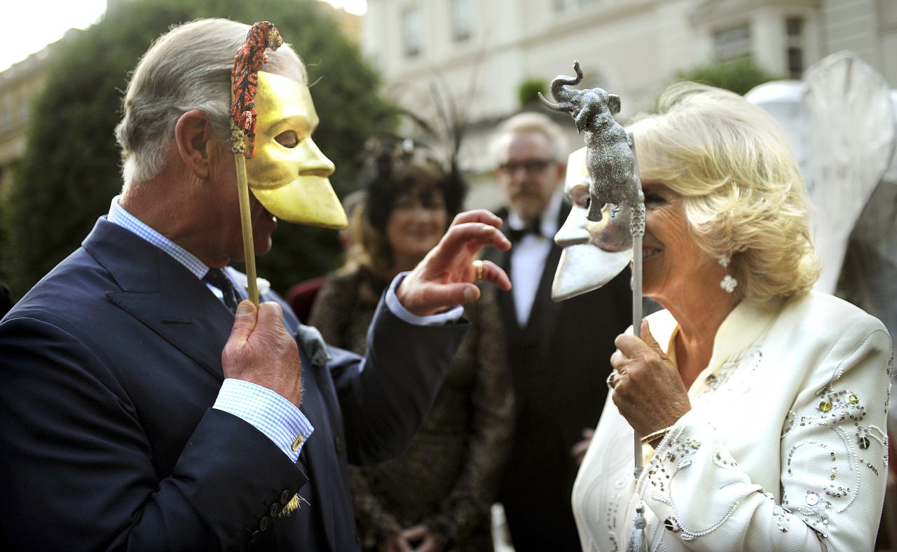 Charles and Camilla pose with masks as they host a charity reception in London in July 2013.