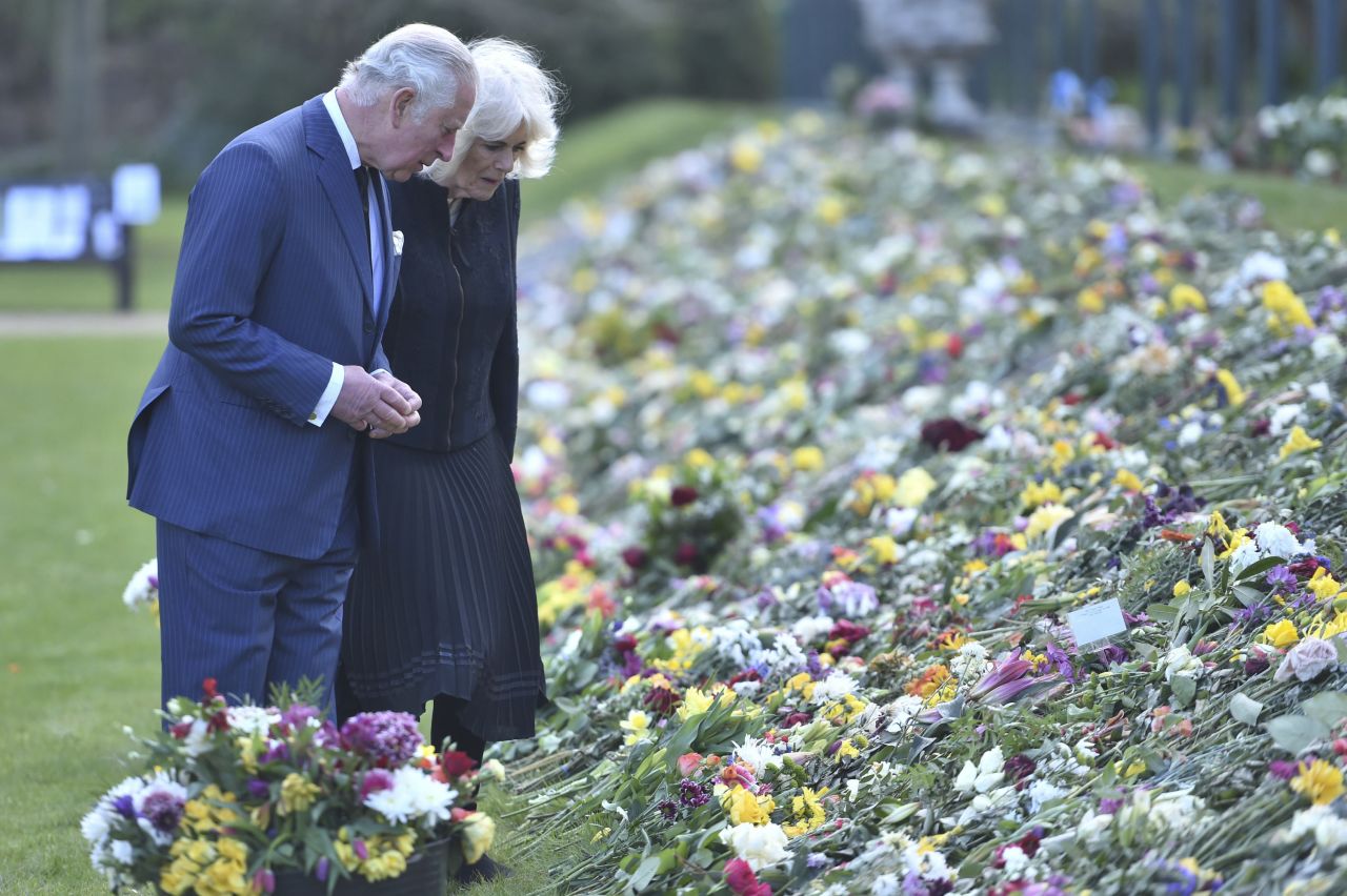 Charles and Camilla view flowers and messages left outside Buckingham Palace after the death of Charles' father, Prince Philip, in April 2021.