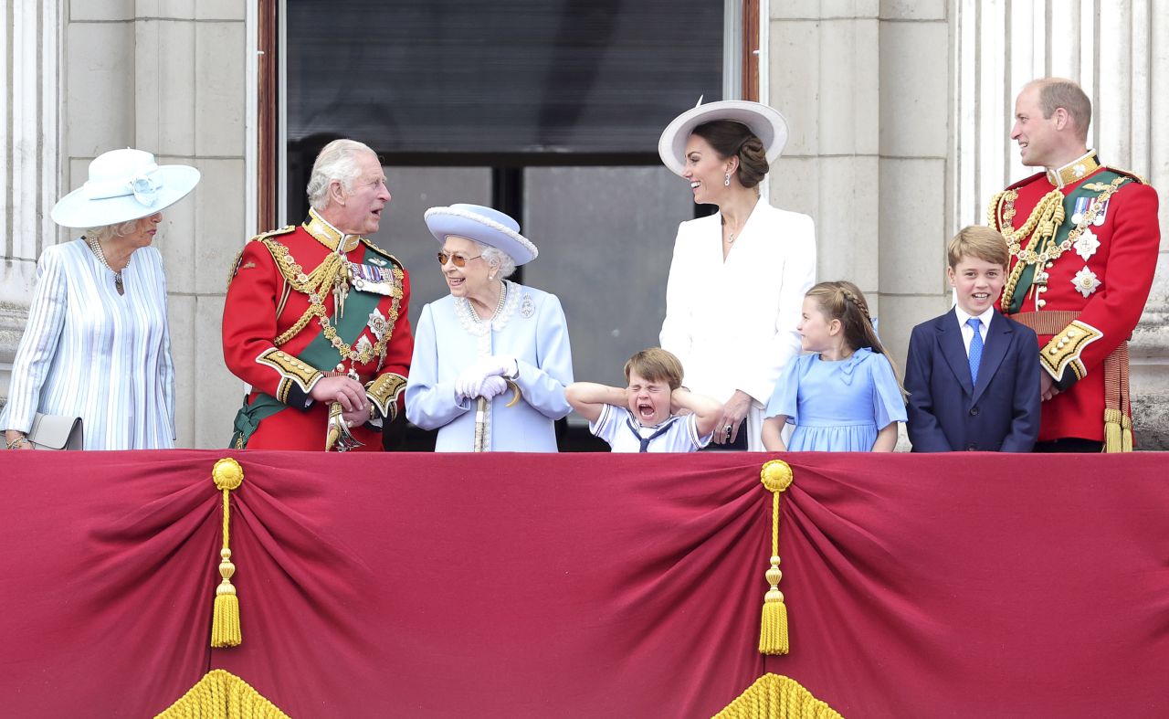 Prince Louis holds his hands over his ears as jets roar over Buckingham Palace during the Trooping the Colour parade in London in June 2022. From left are Camilla, Charles, Queen Elizabeth II, Prince Louis, Duchess Catherine, Princess Charlotte, Prince George and Prince William.