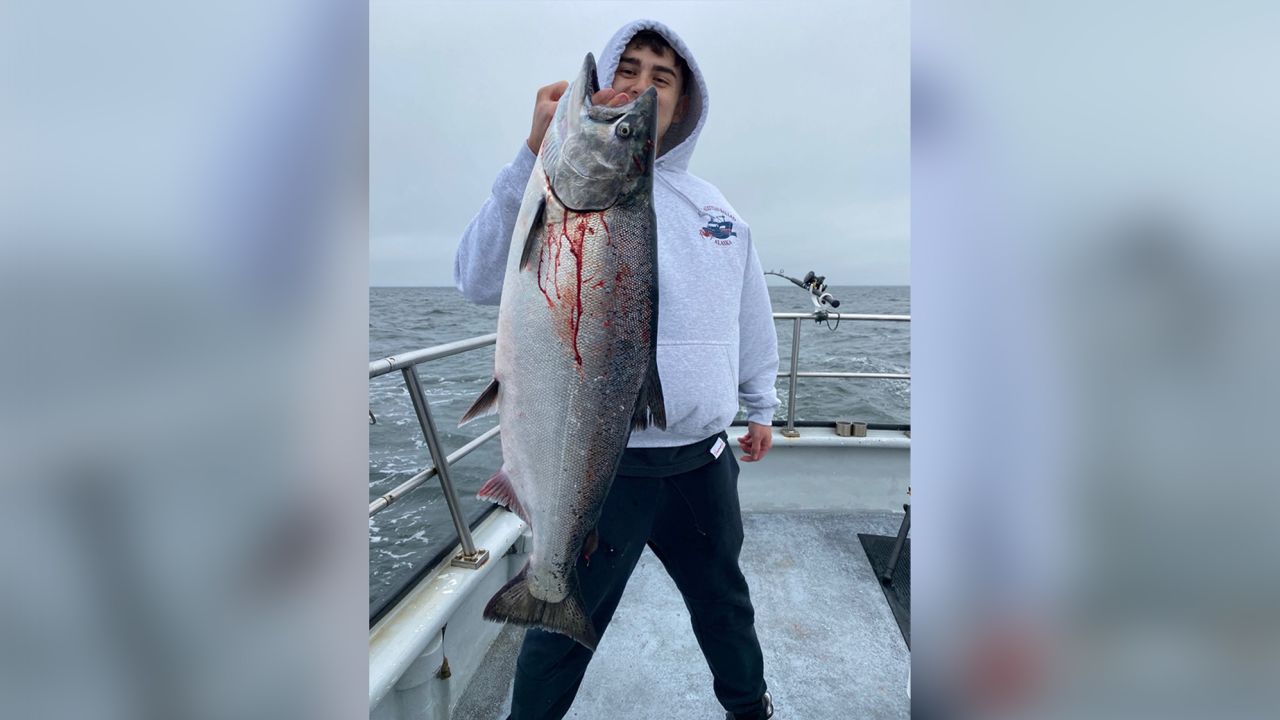 Angelo Guiliano holds a freshly caught Chinook salmon. His father, Andy, runs charter fishing expeditions for recreational salmon fishing in Emeryville, California.