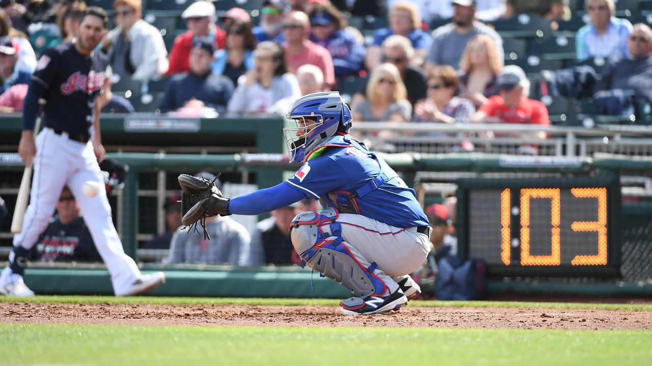 GOODYEAR, AZ - FEBRUARY 25:  Jose Trevino #71 of the Texas Rangers catches a warm up pitch as the pitch clock ticks down during the third inning of a spring training game against the Cleveland Indians at Goodyear Ballpark on February 25, 2019 in Goodyear, Arizona.  (Photo by Norm Hall/Getty Images)