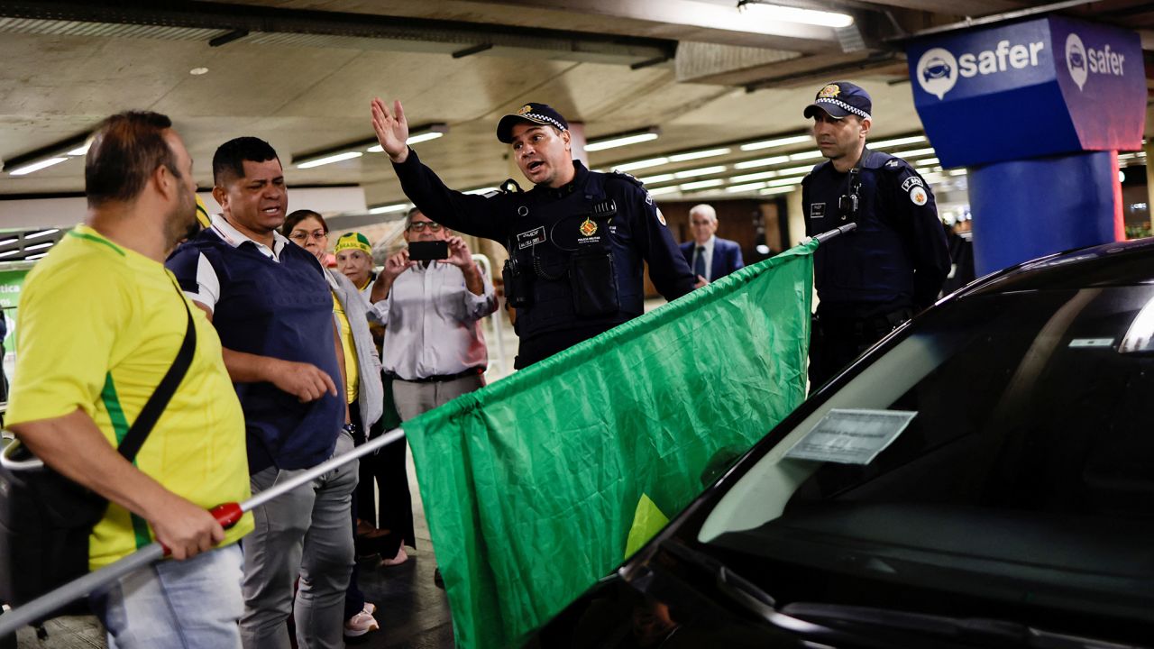 Bolsonaro supporters and members of the Brazilian security services at Brasilia airport on Thursday.