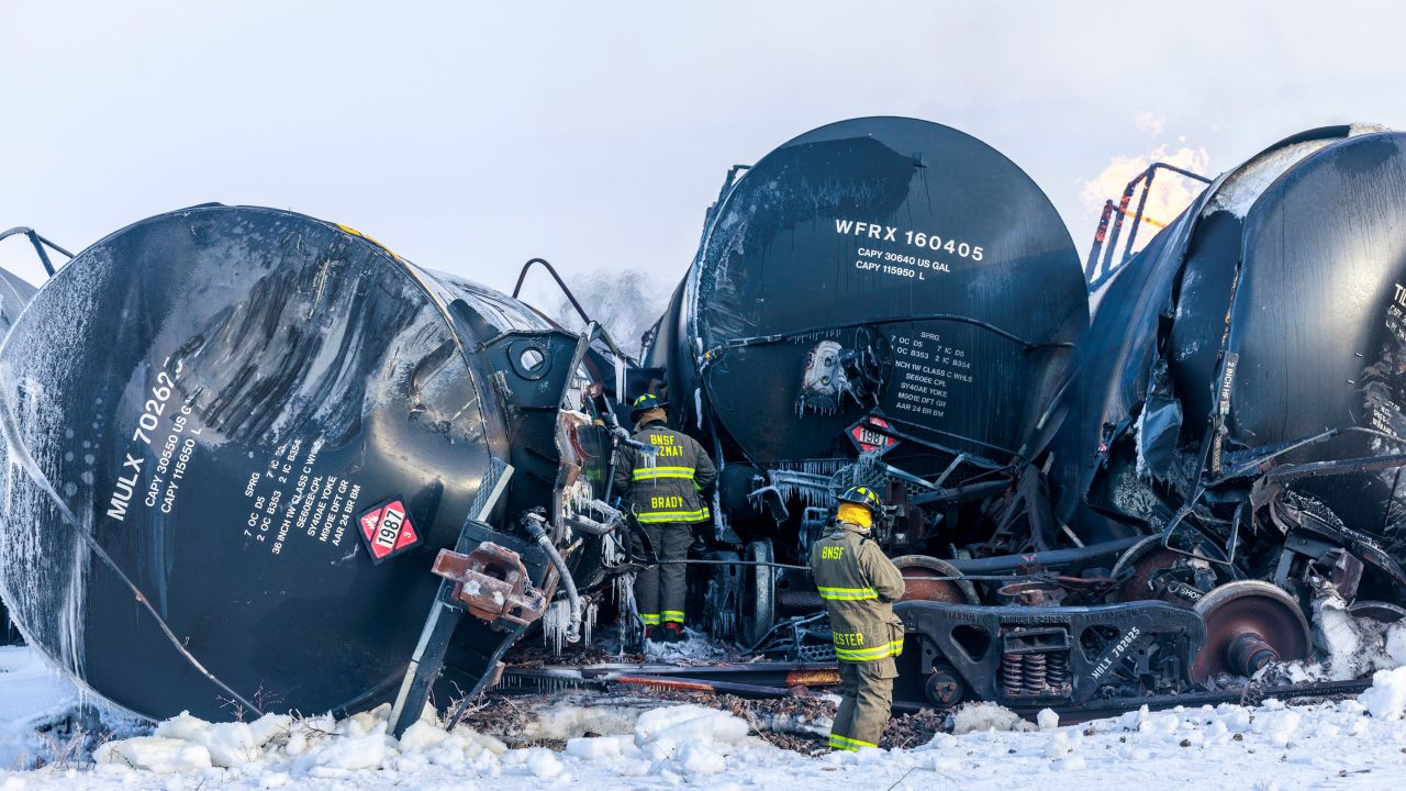 Firefighters work near piled up train cars, near Raymond on March 30, 2023.