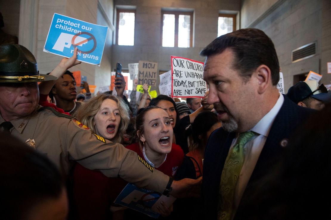 Addie Brue, 16, and Madeline Lederman, 17, shout "do something," with other protesters as Rep. Jeremy Faison, Chairman of the House Republican Caucus, walks towards the House chamber doors at the State Capitol Building in Nashville, on Thursday.