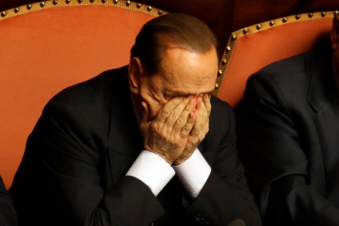 Berlusconi rubs his eyes after delivering a speech in Rome in October 2013. That month, Berlusconi was preliminarily indicted on allegations he bribed a senator to support his party in 2006. He would be convicted in 2015 and banned from holding public office for five years.