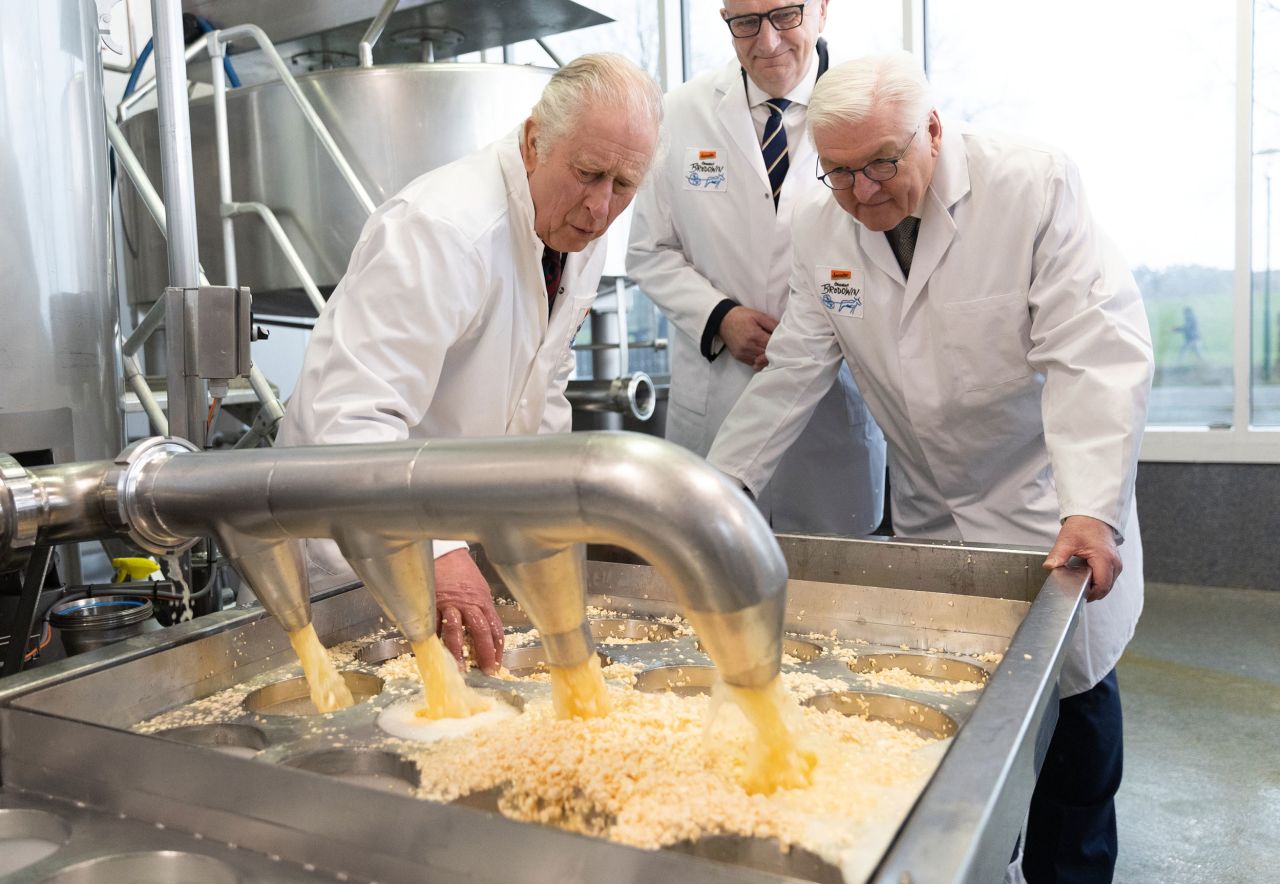 Britain's King Charles III, left, and German President Frank-Walter Steinmeier, right, try cheese-making during a visit to Brodowin, Germany, on Thursday, March 30. <a href="http://www.cnn.com/2023/03/29/europe/gallery/king-charles-visits-germany/index.html" target="_blank">See more photos from the King's visit to Germany</a>.