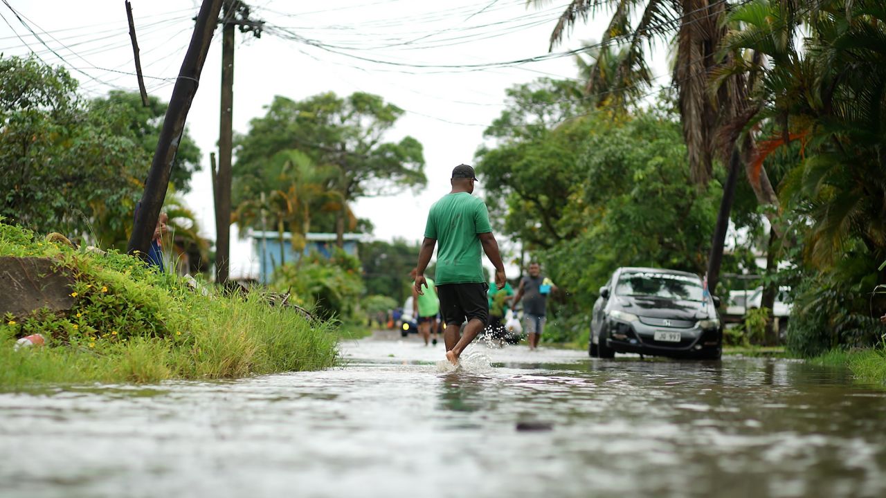 Residents wade through flooded streets in Fiji's capital city of Suva in December 2020 as Cylone Yasa approached.