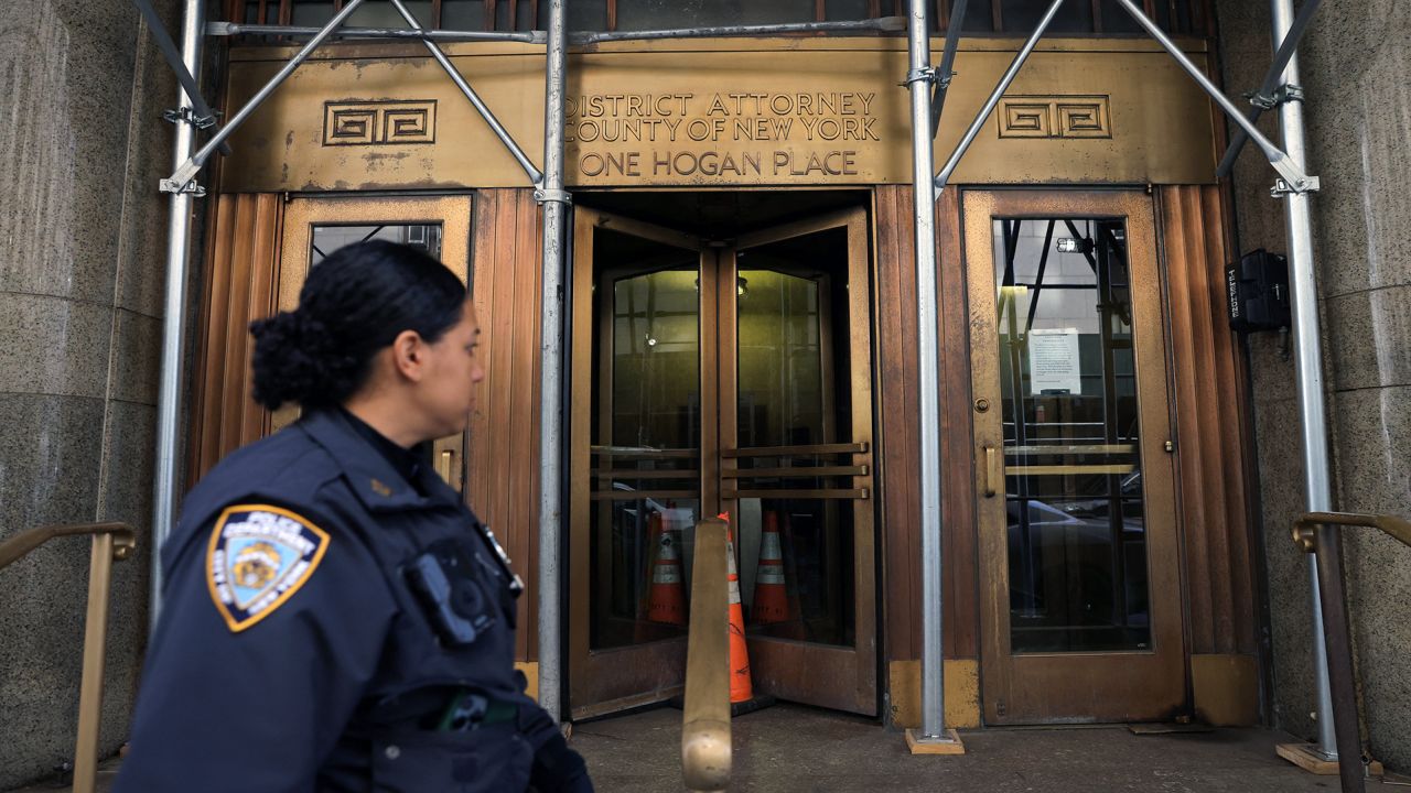 A New York City Police Department (NYPD) officer walks by the office of Manhattan District Attorney Alvin Bragg 