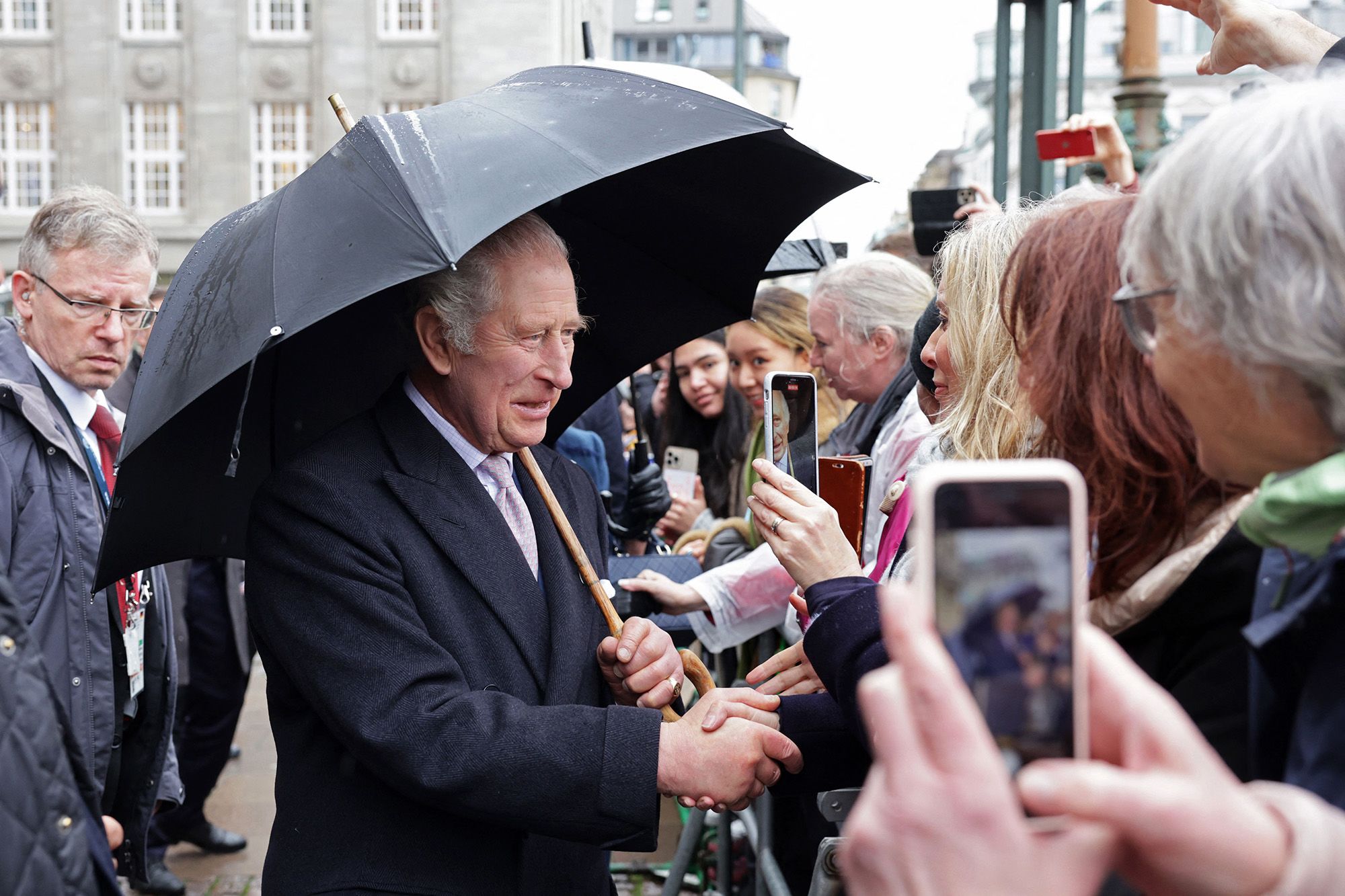 The King greets people Friday outside Hamburg's City Hall.