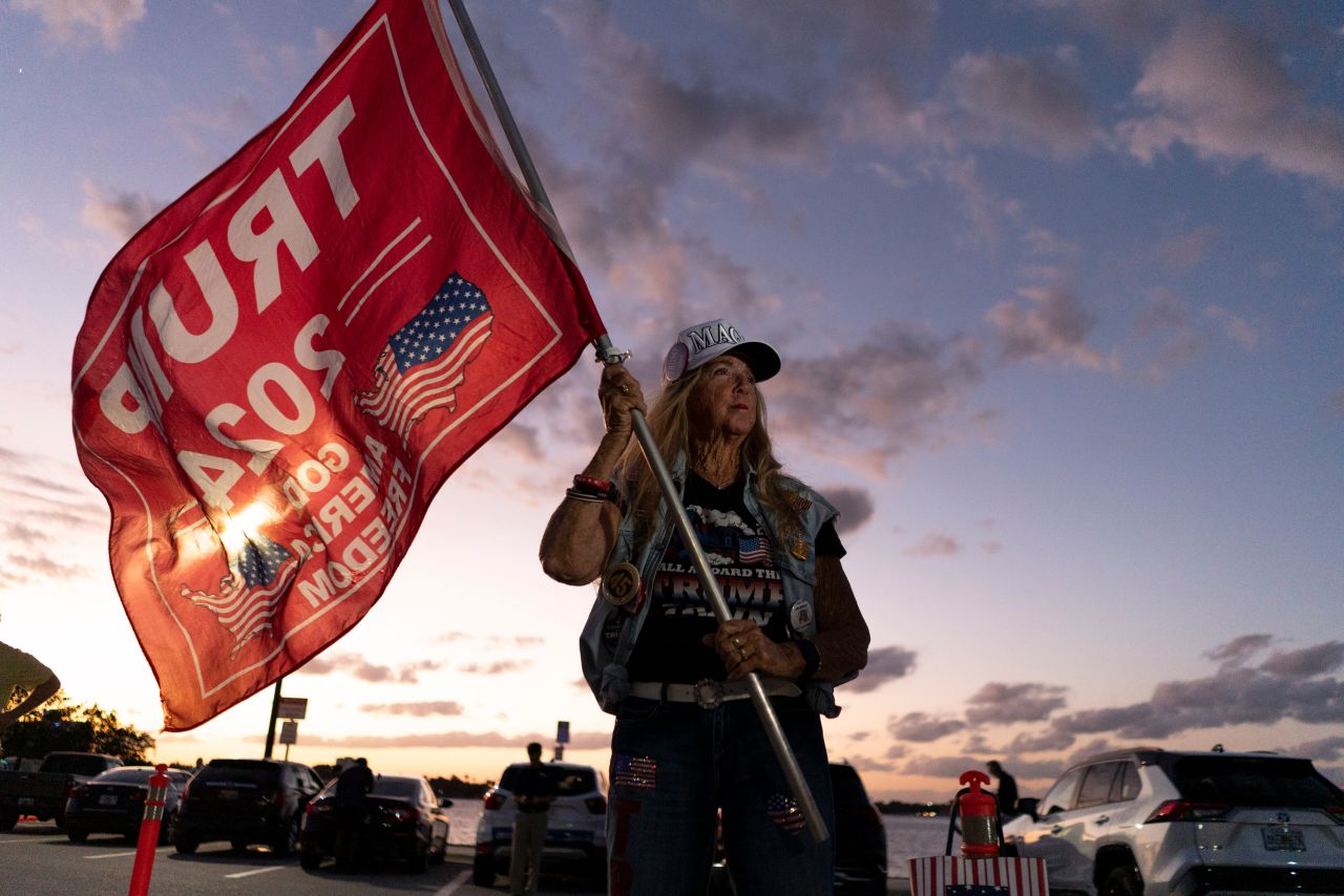 Mary Kelley waves a Trump flag near the former president's Mar-a-Lago estate after he was indicted on March 30.