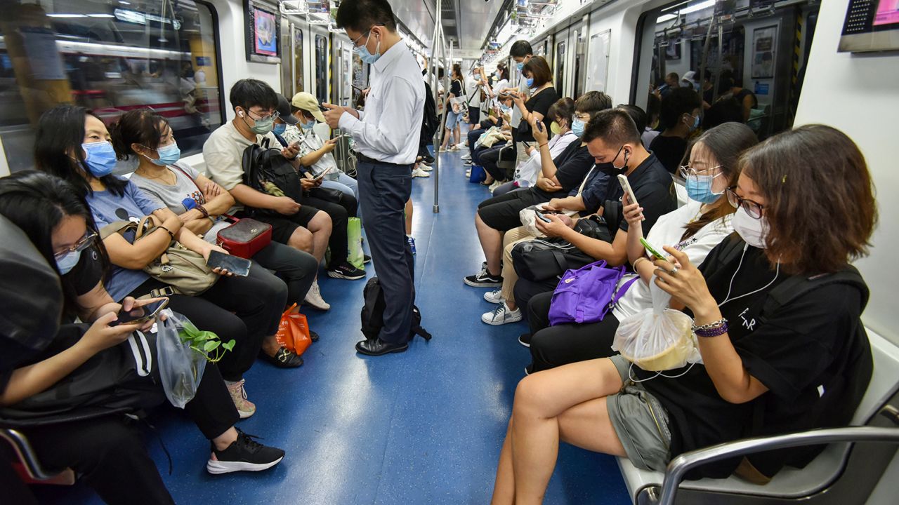 People using their phones on the Beijing subway in July 2022.