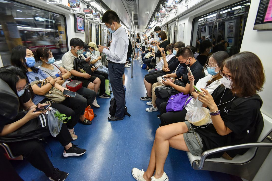 People using their phones on the Beijing subway in July 2022.