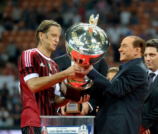 Berlusconi hands the Berlusconi Trophy to AC Milan's Massimo Ambrosini in August 2011. The trophy is awarded annually to the winner of a friendly football match in Milan.