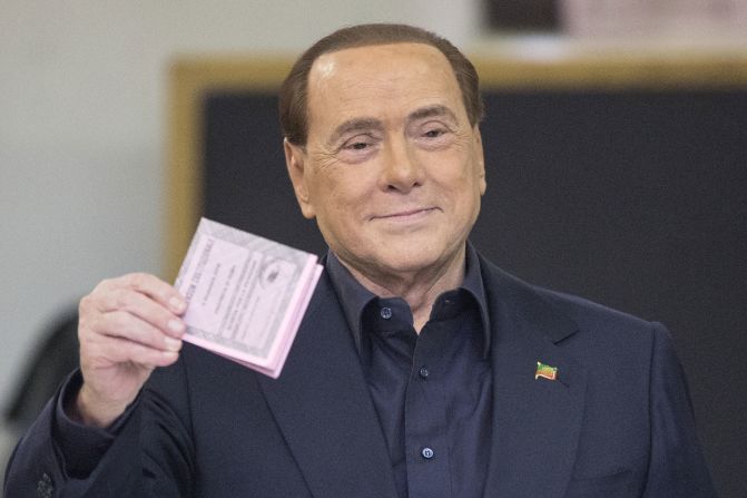 Berlusconi holds his ballot before casting his vote in the referendum on constitutional reform in December 2016.