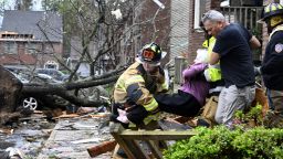 Firefighters carry a woman out of her condo after her complex was damaged by a tornado, Friday, March 31, 2023 in Little Rock, Ark. A monster storm system tore through the South and Midwest on Friday, spawning tornadoes that shredded homes and shopping centers, overturned vehicles and uprooted trees as people raced for shelter.