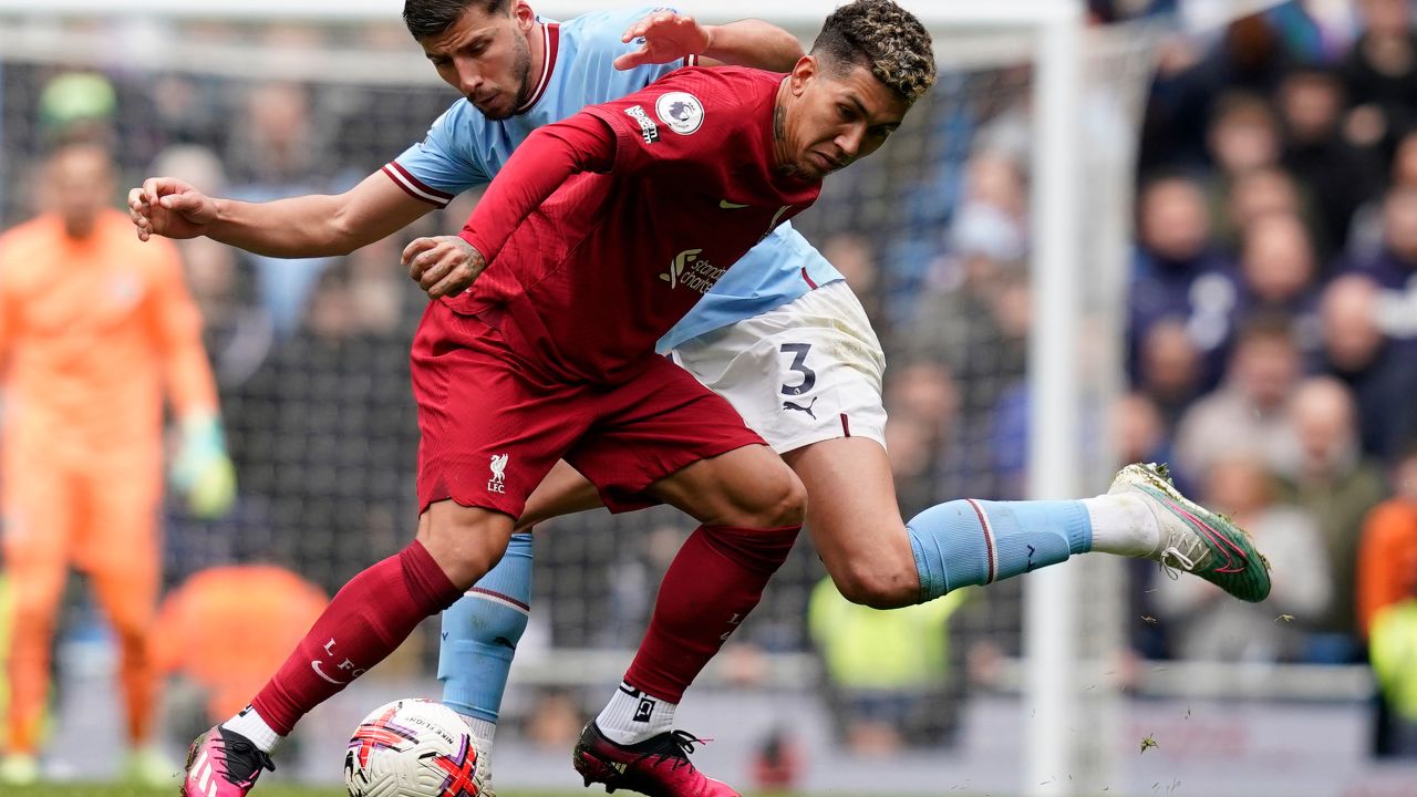 Liverpool's Roberto Firmino is challenged by City's Ruben Dias on Saturday. 