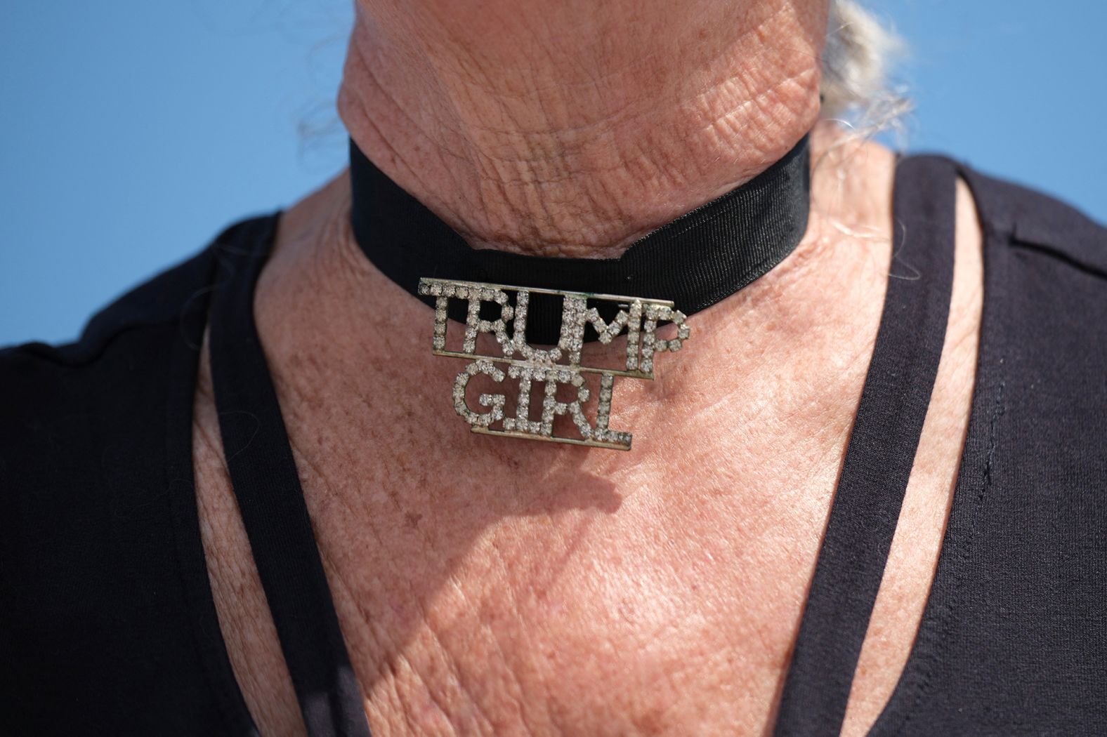 A woman wears a choker necklace that reads "Trump Girl" outside Trump's Mar-a-Lago resort on April 2.