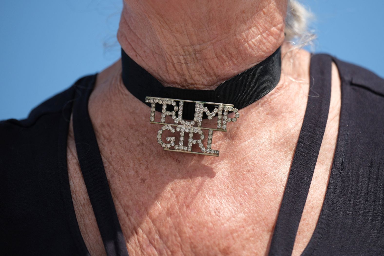 A woman wears a choker necklace that reads "Trump Girl" outside Trump's Mar-a-Lago resort on April 2, 2023.