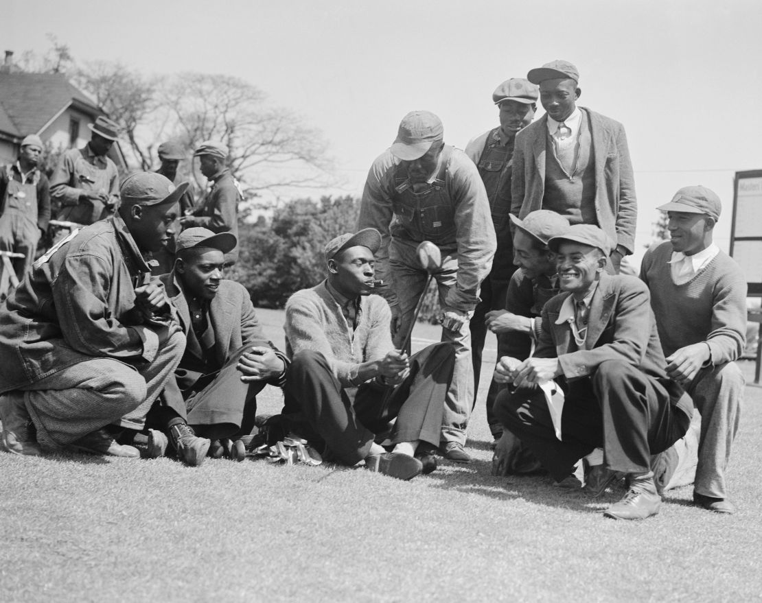 John H. "Stovepipe" Gordon (center), caddie for Gene Sarazen, shows fellow caddies the club Sarazen made a double eagle with at the 1935 Masters.