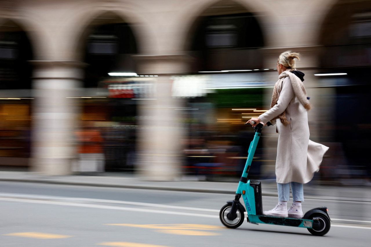 A woman rides an electric scooter from a sharing service in Paris on on April 1.