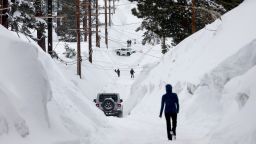 A road is lined with snowbanks piled up from new and past storms, after yet another storm system brought heavy snowfall further raising the snowpack on March 29, 2023 in Mammoth Lakes, California. 