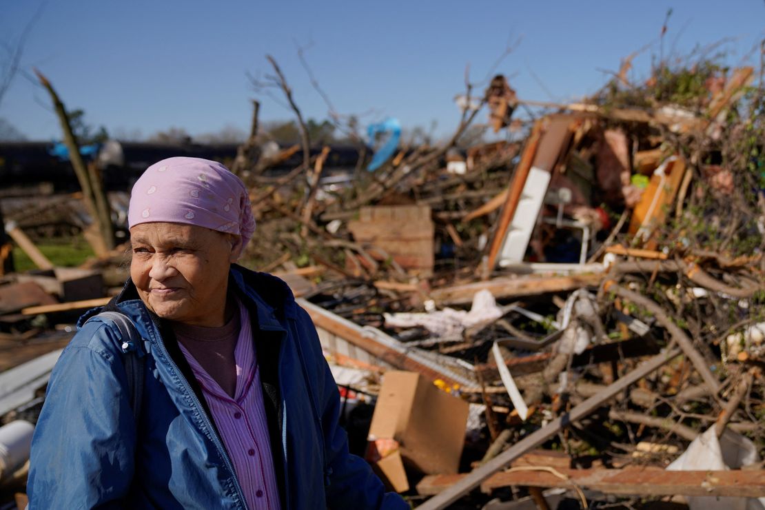 Clema Smith, who was trapped and rescued from the rubble in Wynne, Arkansas, stands in front of the wreckage of her home Saturday.