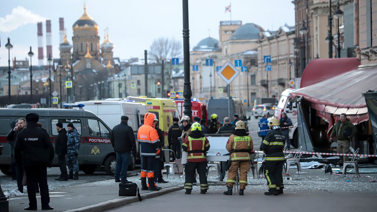 Russian Emergency Situations Ministry staff stand at the side of an explosion at a cafe in St. Petersburg, Russia, Sunday, April 2, 2023. 