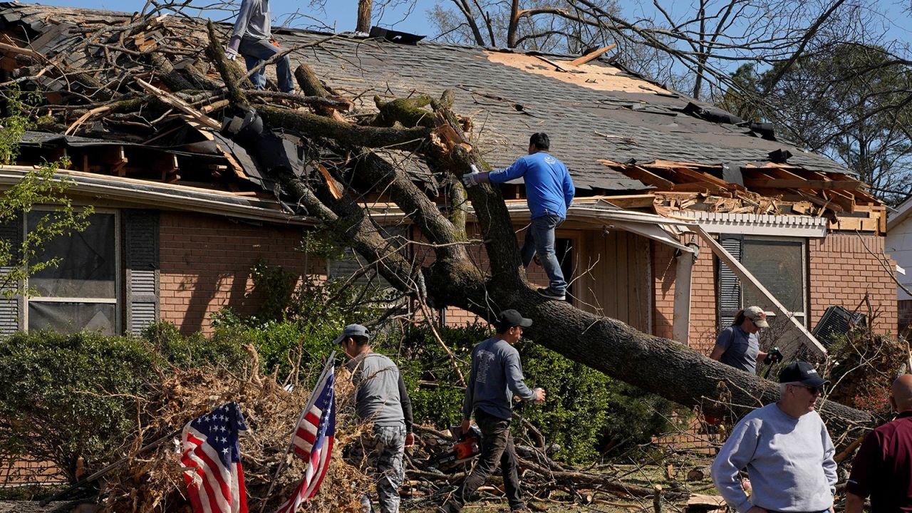 People work to remove a tree that fell onto a home, in the aftermath of a tornado in Little Rock, Arkansas, Sunday.
