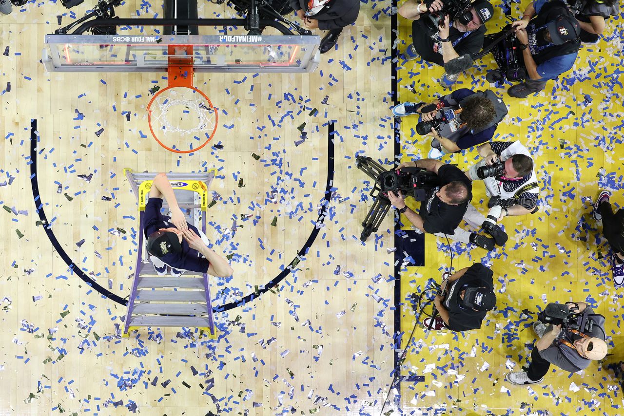 UConn's Andrew Hurley helps cut down the nets after the game. Hurley is also the son of UConn head coach Dan Hurley.