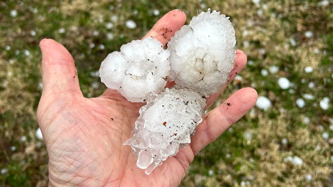 A man holds large hail in Davenport, Iowa, which saw hail as large as softballs in some cases.