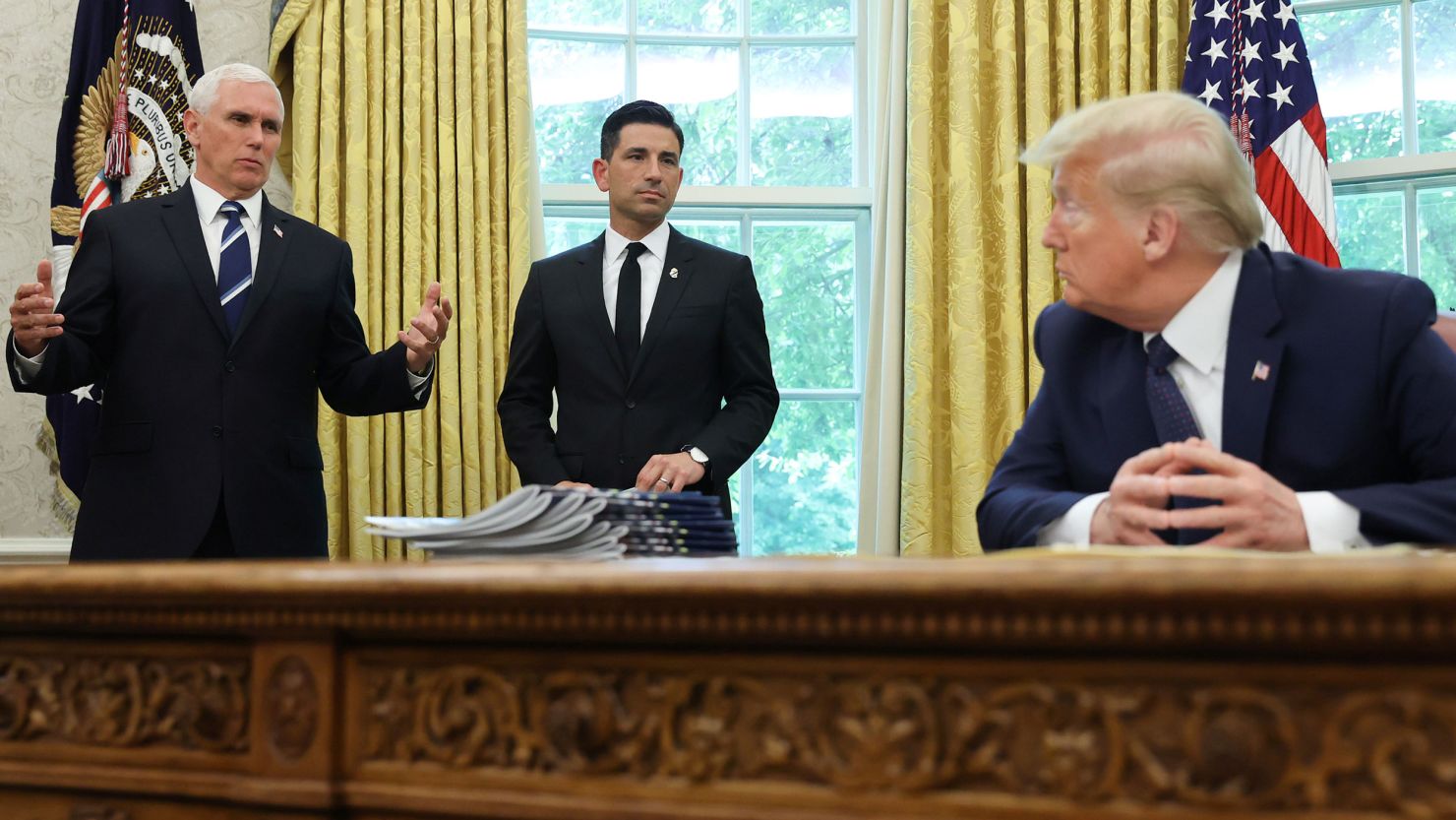 Then-US President Donald Trump listens to Vice President Mike Pence and acting Secretary of Homeland Security Chad Wolf, May 28, 2020.