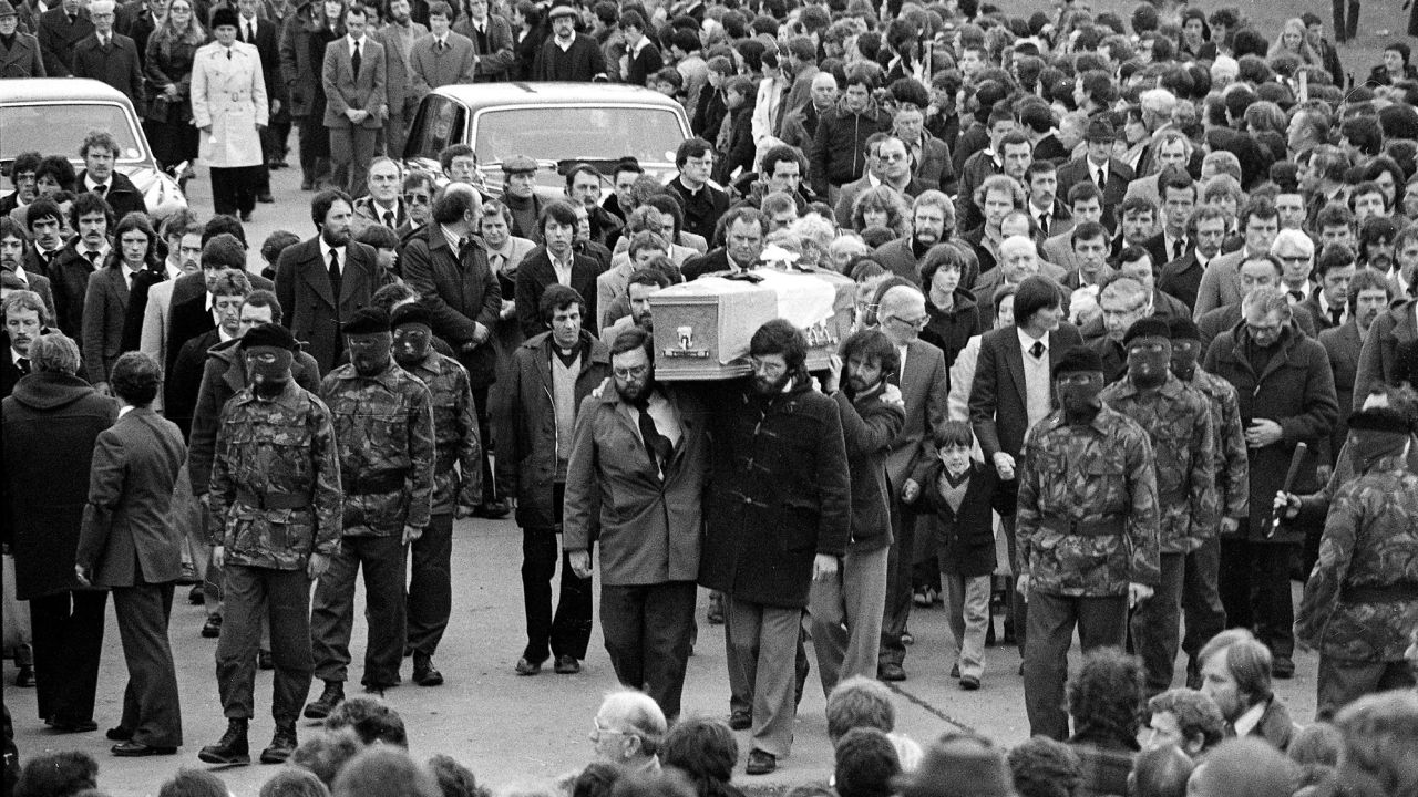 Seven-year-old Gerard Sands walks beside the coffin of his father, Catholic hunger striker Bobby Sands, as it is escorted to Belfast's Milltown Cemetery by masked IRA men on May 7, 1981.
