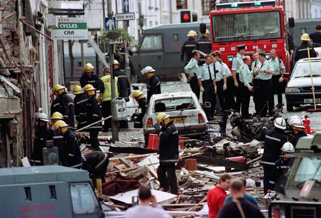 Royal Ulster Constabulary police officers and firefighters inspect the damage caused by a bomb explosion in Market Street, Omagh, Co Tyrone, Northern Ireland.