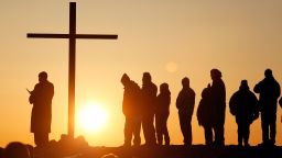 People are silhouetted as the sun rises during an Easter sunrise service in Scituate, Massachusetts March 31, 2013.  REUTERS/Jessica Rinaldi (UNITED STATES - Tags: RELIGION SOCIETY)