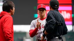 Los Angeles Angels starting pitcher Shohei Ohtani talks with home plate umpire Pat Hoberg after the first inning of a baseball game, in which he was called for a pitch clock violation against the Seattle Mariners, Wednesday, April 5, 2023, in Seattle. (AP Photo/Lindsey Wasson)