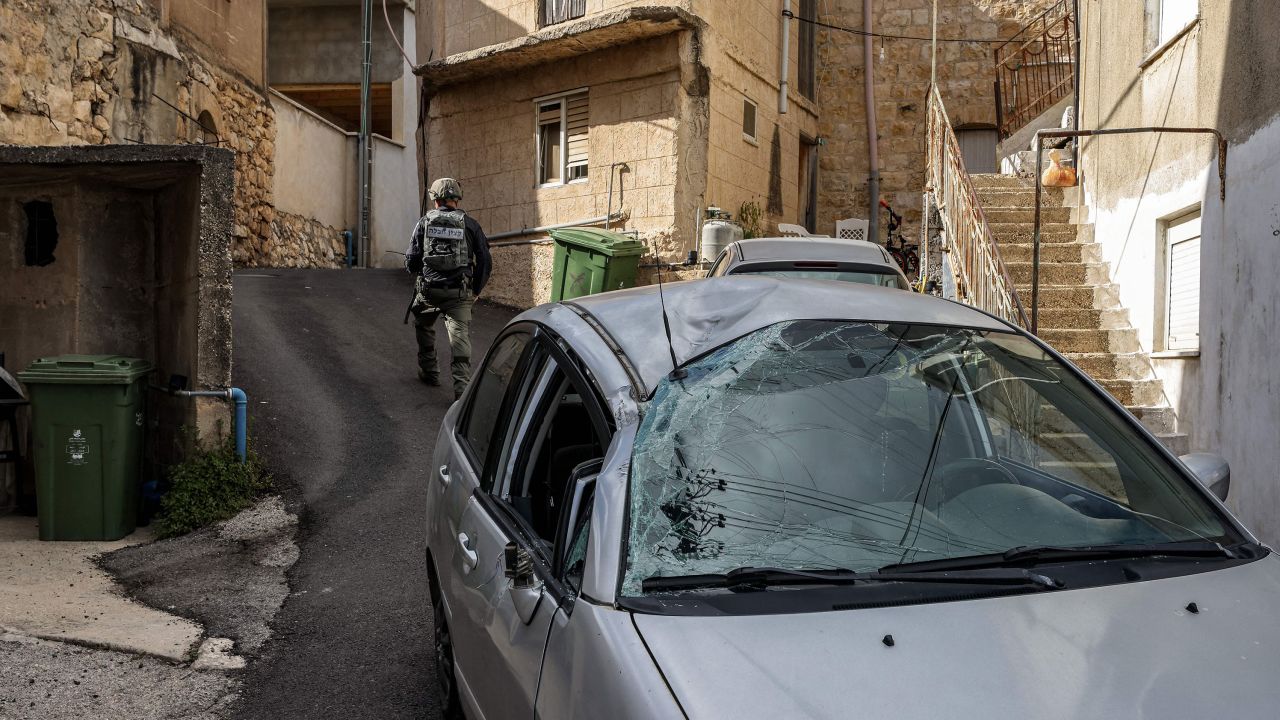Un miembro de la unidad de desactivación de bombas de la policía israelí pasa junto a un automóvil dañado, después de que se lanzaran cohetes desde el Líbano y fueran interceptados por Israel el jueves.