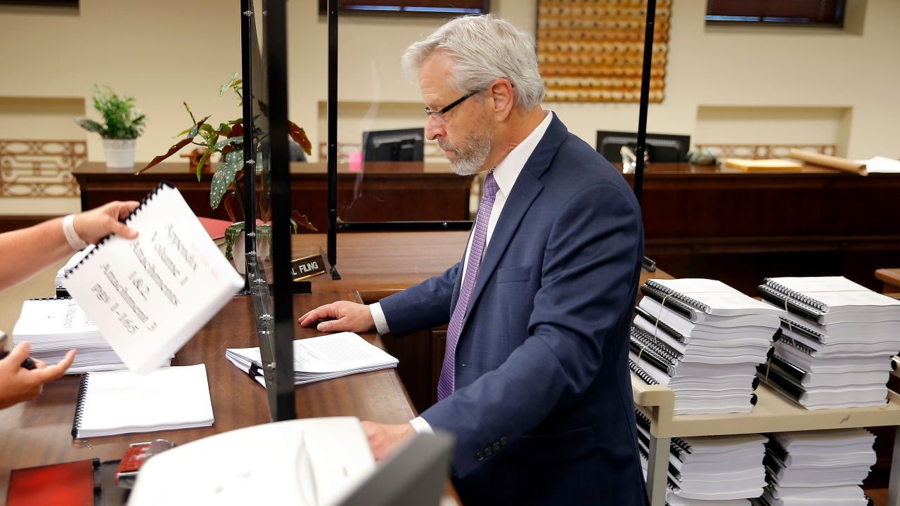 Richard Glossip's attorney, Don Knight, hands over documents inside the Oklahoma Court of Criminal Appeals in July 2022 as he files for a new hearing for his client.