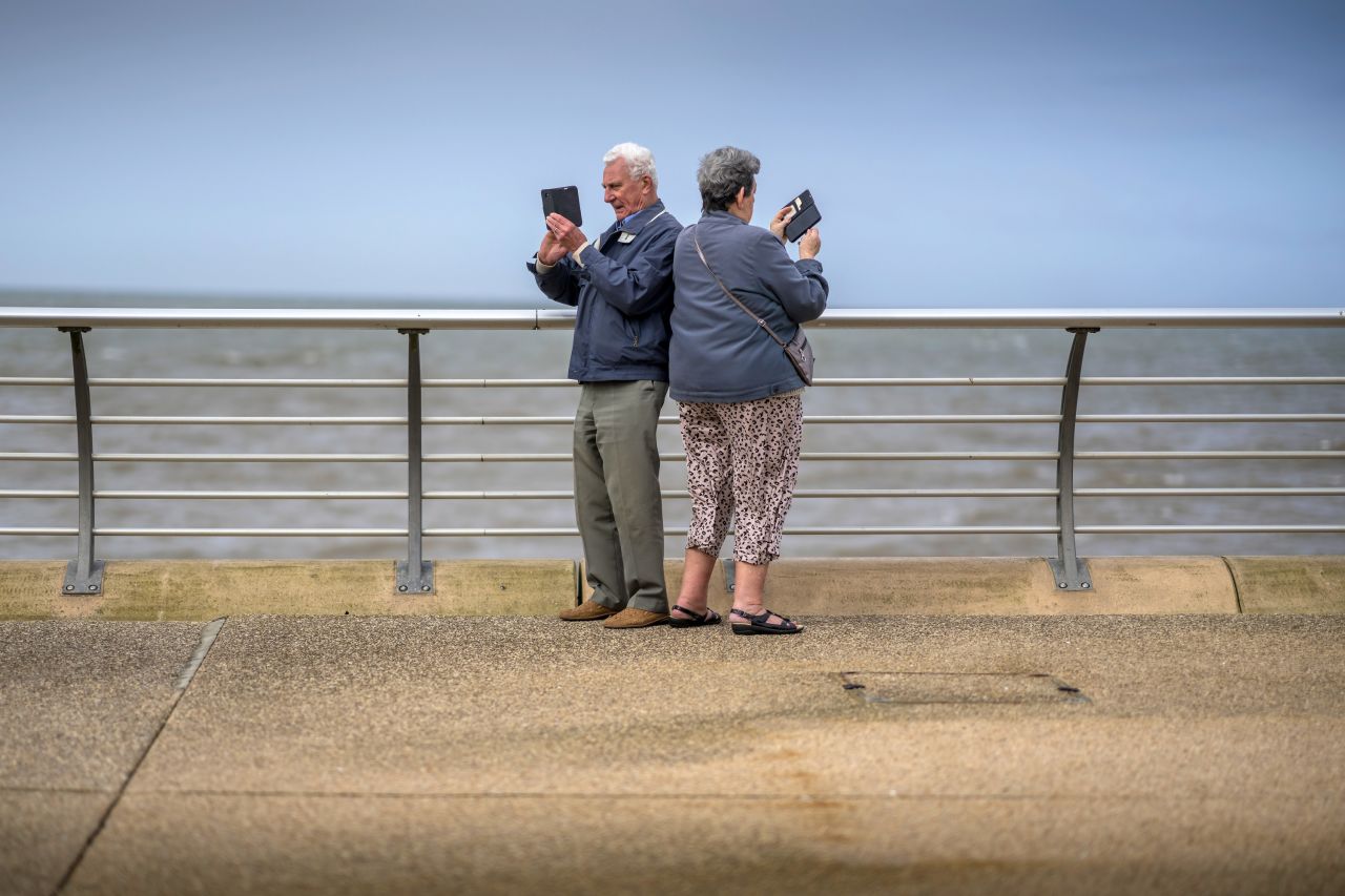 People take photos on the promenade in Blackpool, England, on Thursday, April 6.