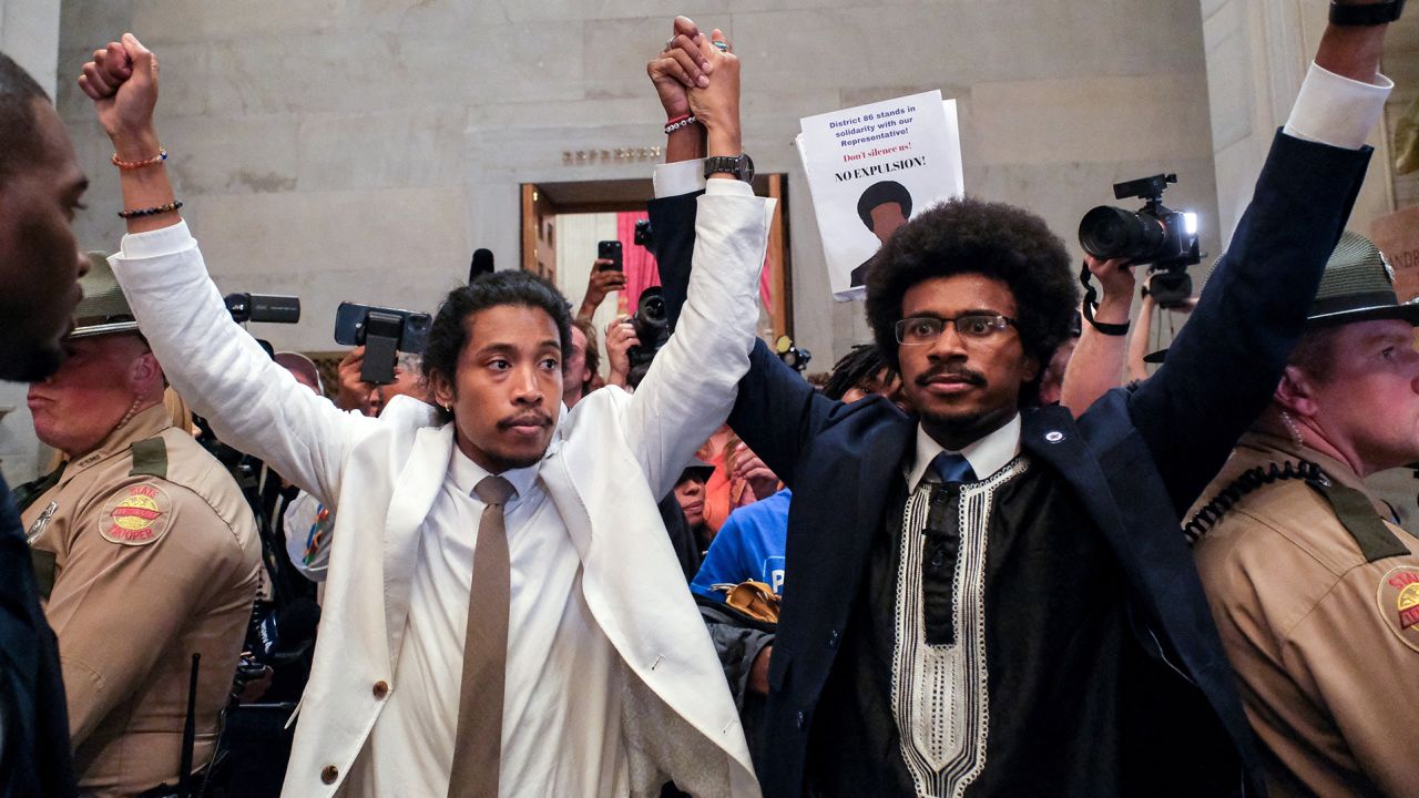 Justin Pearson and Justin Jones raise their hands after being expelled from their seats in the Tennessee House in Nashville Thursday.